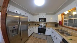 a kitchen with white cabinets and a stainless steel refrigerator at River Dream Lake Murray Getaway in Saluda