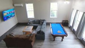 a living room with a couch and a pool table at River Dream Lake Murray Getaway in Saluda +12 photos
