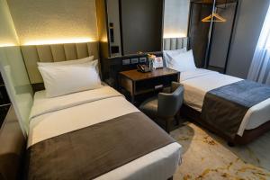 Habitación de hotel con 2 camas y escritorio en Amber Hotel - Cebu en Cebú