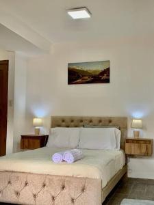 ein Schlafzimmer mit einem Bett mit zwei lila Handtüchern darauf in der Unterkunft Urban Andes Retreat in Cuenca