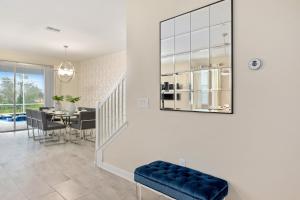 a living room with a table and a mirror on the wall at 1509 MC - Exquisite 8BR Villa with Pool Games in Davenport +35 photos