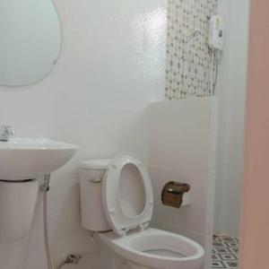 een witte badkamer met een toilet en een wastafel bij บ้านชมดาวรีสอร์ทบึงโขงหลง in Ban Don Klang