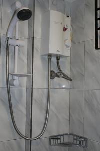 y baño con ducha y máquina en la pared. en Anahaw Studio Suites, en Boracay