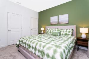 a bedroom with a large bed with a green wall at 1056 LS - Luxury 4BR3BA - Champions Gate Bliss in Kissimmee