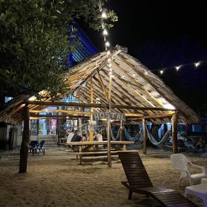 a group of people sitting under a pavilion at night at Hostel Beach House in Rincón