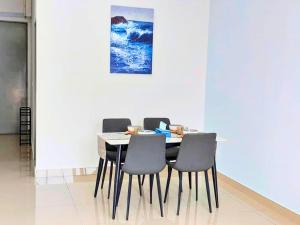 a dining room table with chairs and a painting on the wall at Bayu Temiang Seremban- Your Urban Retreat in Seremban
