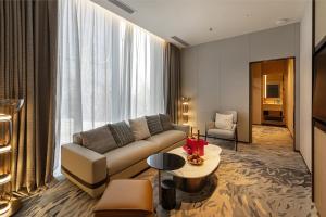 a living room with a couch and a table at Novotel Xi'an Aden in Xi'an