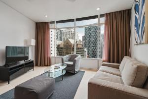 a living room with a couch and a large window at Vortex KLCC Apartments in Kuala Lumpur