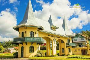 a large yellow building with towers on top of it at Quarto Aconchegante na - Peniel Guesthouse in Gramado