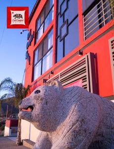 uma estátua de um cão em frente a um edifício em HOTEL CALICOMFORT em Tecate