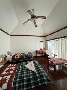 1 dormitorio con 2 camas y ventilador de techo en Club ES Deurali Resort, en Pokhara