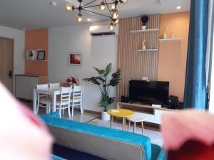 uma sala de estar com um sofá, uma mesa e uma televisão em May house Green Bay Garden Hạ Long - near Marina beach em Ha Long