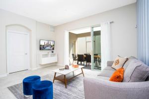 een woonkamer met een bank en een tafel bij 1169 CD - Game Room Condo: Pool Disney Nearby in Kissimmee