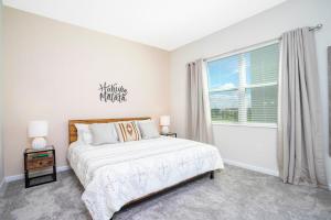 een slaapkamer met een bed en een groot raam bij 1169 CD - Game Room Condo: Pool Disney Nearby in Kissimmee