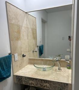 uma casa de banho com um lavatório de vidro e um espelho. em Casa la bien amada em Merlo
