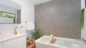 a bathroom with a white tub and a sink at Natures Nest on Nari in Moss Vale