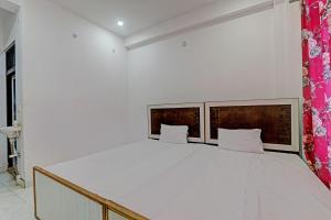 ein Schlafzimmer mit einem großen weißen Bett in einem Zimmer in der Unterkunft OYO ONCE MORE RESTAURANT AND CAFE in Lukerganj