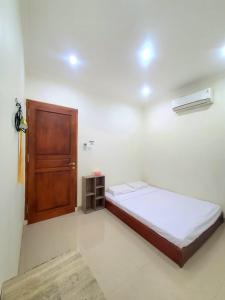 - une chambre avec un lit et une porte en bois dans l'établissement HOUSE IN SURAKARTA, à Grogol