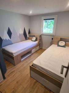 a room with two beds and a window at Chalet Le Parc de Latour, au pied de la montagne in Latour-de-Carol