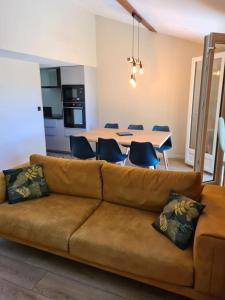 a living room with a couch and a table with chairs at Chalet Le Parc de Latour, au pied de la montagne in Latour-de-Carol
