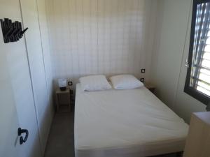 a small bedroom with a white bed with two pillows at Chalet Olonzac, 4 pièces, 6 personnes - FR-1-783-1 in Olonzac