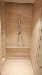 a shower with a hose in a wooden shower stall at Howard Johnson Changsheng Plaza Meizhou in Meizhou