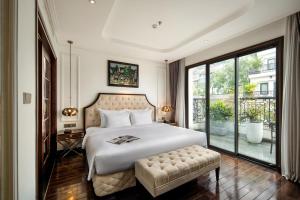 a bedroom with a large bed and a large window at Anatole Hotel Hanoi in Hanoi
