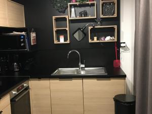 a kitchen with a sink and a black wall at Chalet 3 chb, 2 sde, domaine sécurisé avec piscine chauffée, proche plages Méditerranée - FR-1-783-22 in Pomérols