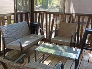 2 Stühle und ein Tisch auf einer Terrasse in der Unterkunft Chalet 2 Chambres à Labouheyre avec Piscine Chauffée, WiFi et Terrasse au Bord d'un Lac - FR-1-783-25 in Labouheyre + 2 Fotos