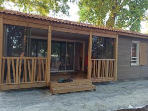 eine abgeschirmte Veranda eines Hauses mit Glas in der Unterkunft Chalet 2 Chambres à Labouheyre avec Piscine Chauffée, WiFi et Terrasse au Bord d'un Lac - FR-1-783-25 in Labouheyre