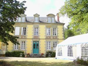 uma grande casa amarela com uma estufa em frente em Gîte Gipcy, 6 pièces, 10 personnes - FR-1-489-504 