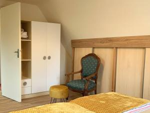 um quarto com uma cadeira, uma cama e um armário em Appartement Trégastel, 2 pièces, 2 personnes - FR-1-368-413 em Trégastel