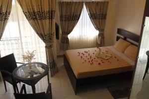 1 dormitorio con 1 cama con pétalos de rosa rojo en Anahaw Studio Suites, en Boracay