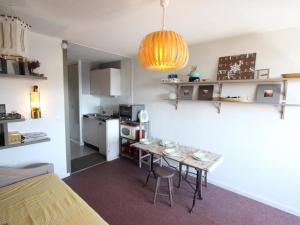 a small room with a table and a kitchen at Studio Chamrousse, 1 pièce, 4 personnes - FR-1-549-138 in Chamrousse