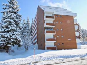 a apartment building in the snow with a tree at Studio Chamrousse, 1 pièce, 4 personnes - FR-1-549-138 in Chamrousse