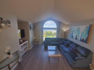 een woonkamer met een blauwe bank en een tafel bij K E vacation house in Nanaimo