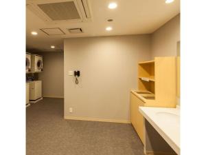 a bathroom with a sink and a wall at Y's Hotel Asahikawa Ekimae - Vacation STAY 65443v in Asahikawa