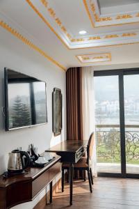ein Hotelzimmer mit einem Tisch und einem Balkon in der Unterkunft Trung Huyền Hotel in Sa Pa