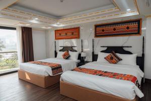 ein Hotelzimmer mit 2 Betten und einem Fenster in der Unterkunft Trung Huyền Hotel in Sa Pa