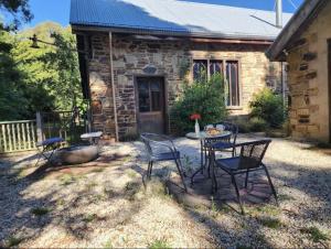 a table and chairs in front of a stone house at Daylesford - FROG HOLLOW ESTATE - One Bedroom Retreat Villa - book for 3 nights pay for 2 - contact us for more details in Daylesford