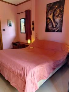 a bedroom with a large bed with a pink blanket at Nirvana Pool Villa 2 in Nong Prue +57 photos