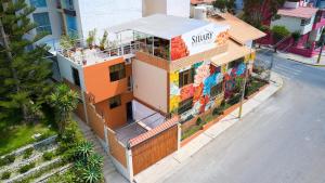 ein orangefarbenes Gebäude mit Graffiti darauf neben einer Straße in der Unterkunft SILLARY HOSTAl SEDE CAYMA in Arequipa