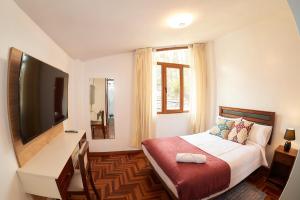 Schlafzimmer mit einem Bett, einem TV und einem Fenster in der Unterkunft SILLARY HOSTAl SEDE CAYMA in Arequipa