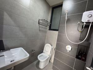 a bathroom with a toilet and a sink at DeLuma-Urban Suites in Jelutong