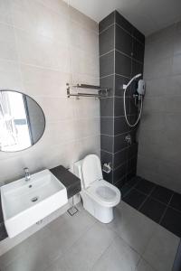 a bathroom with a toilet and a sink and a shower at DeLuma-Urban Suites in Jelutong