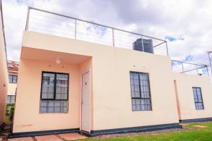 ein weißes Gebäude mit Balkon darüber in der Unterkunft Unity homes #G08 in Eldoret