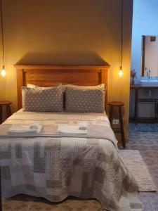 uma cama grande com uma cabeceira de madeira num quarto em Villa das Palmeiras Chalés & Camping em São Bento do Sapucaí