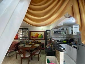 a kitchen with a table and a dining room at Casa Vecina Hostal in Santa Marta