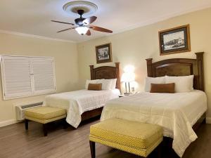 a bedroom with two beds and a ceiling fan at Hotel Caesars in Tijuana