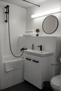 uma casa de banho branca com um lavatório e um espelho em Apartment am Ossiachersee mit eigenem Seezugang em Landskron